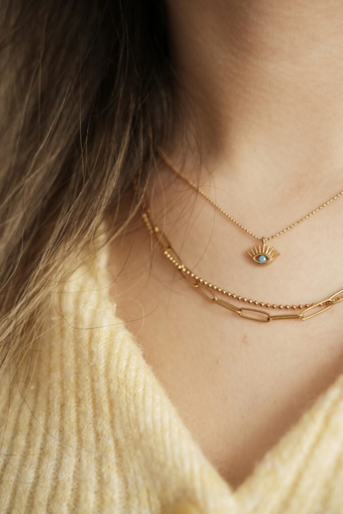 Close-up of two exquisite gold necklaces adorning the neck, showcasing luxury and elegance.